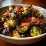 Close-up of a bowl of Balsamic Roasted Brussels Sprouts with Bacon, showing crispy edges and savory bacon pieces.