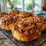 Close-up of delicious Caramel Pecan Sticky Buns, generously topped with nuts and gooey caramel, cooling on a wire rack.