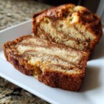 A close-up of a slice of Cinnamon Swirl Banana Bread, showcasing the beautiful swirls of cinnamon and banana.