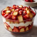 A beautiful Strawberry Shortcake Trifle layered in a glass bowl with fresh strawberries, whipped cream, and cake pieces.