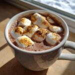 A close-up of a mug filled with Toasted Marshmallow Hot Chocolate, topped with perfectly toasted marshmallows.