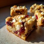 Close-up of a delicious White Chocolate Cranberry Blondie, showing chunks of white chocolate and dried cranberries.