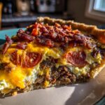 A close-up of a slice of Bacon Onion Tomato Pie, showcasing layers of crispy bacon, melted cheese, and fresh tomato slices.