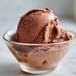 A scoop of rich chocolate ice cream made from frozen bananas in a glass bowl.