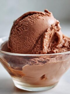 A scoop of rich chocolate ice cream made from frozen bananas in a glass bowl.