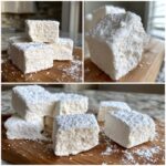 A close-up of fluffy Homemade Marshmallows dusted with powdered sugar on a wooden board.