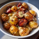 A bowl of Irresistible Cheesy Ranch Potatoes and Smoked Sausage, coated in a creamy sauce and sprinkled with herbs.