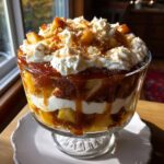 A beautiful Caramel Apple French Toast Trifle layered in a glass bowl with whipped cream and caramel sauce.