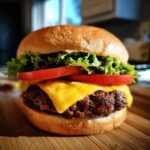A classic cheeseburger with melted cheddar cheese, fresh lettuce, and tomato slices on a toasted bun.