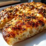 Close-up of a slice of Easy Everything Bagel Cheese Naan Pizza, showing bubbly cheese and everything bagel seasoning.