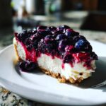 A delicious slice of Irresistible No Bake Blueberry Cheesecake, topped with fresh blueberries and syrup.
