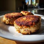 Golden brown, pan-fried Irresistible Salmon Cakes made with canned salmon, served on a white plate.