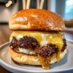 A close-up of an irresistible smash burger with melted cheese and a golden brioche bun.