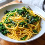 A close-up of Lemon Herb Garlic Parmesan Kale Pasta tossed with bright green kale and topped with grated cheese.