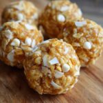 Close-up of several No Bake White Chocolate Energy Bites rolled in oats and white chocolate chips.
