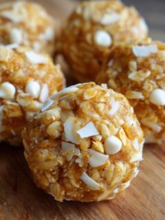 Close-up of several No Bake White Chocolate Energy Bites rolled in oats and white chocolate chips.