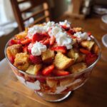 A beautiful Strawberry French Toast Trifle in a glass bowl, layered with cake, strawberries, and whipped cream.