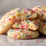 A close-up of a stack of Thick Chewy Funfetti Cookies, showing their soft, chewy interior and colorful sprinkles.
