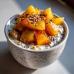 Close-up of Vanilla Overnight Oats topped with glistening Maple Spiced Pears and black sesame seeds.