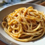 Close-up of creamy Date Night Roasted Garlic Parmesan Bucatini pasta served in a light bowl.