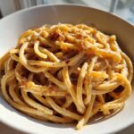 Close-up of creamy Date Night Roasted Garlic Parmesan Bucatini pasta served in a white bowl.