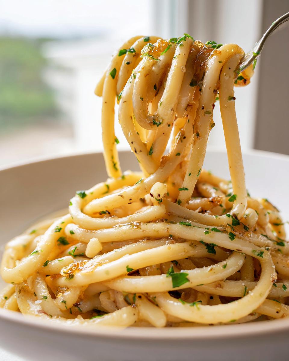 A fork lifting strands of Date Night Roasted Garlic Parmesan Bucatini coated in a rich sauce and fresh parsley.
