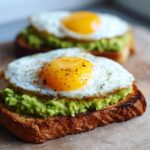 Close-up of Easy Avocado Egg Toast featuring bright green smashed avocado on toasted bread topped with a perfectly cooked sunny-side-up egg.
