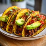 Four crispy tacos filled with seasoned black beans, salsa, and avocado slices, representing Easy Vegan Black Bean Tacos.