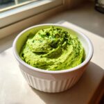 A bright green, creamy Healthy Green Goddess Salad Dip topped with fresh parsley in a white ramekin.