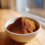 A small white bowl filled with a mound of freshly mixed Homemade Pumpkin Pie Spice Blend.