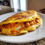 A golden-brown omelette folded over a filling of chili spiced chickpeas and melted orange cheese.