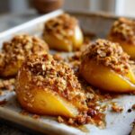 Close-up of baked pears topped with oat crumble, part of the Sheet Pan Maple Roasted Pear Crisp recipe.