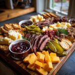 A bountiful BBQ Charcuterie Board featuring sliced smoked brisket, cheddar cubes, pickles, and jam.