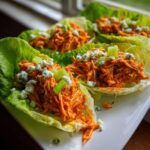 Close-up of delicious Buffalo Chicken Lettuce Boats topped with crumbled blue cheese and celery.