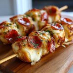 Close-up of melted cheese oozing from warm Bagel Bite Skewers topped with pepperoni and parsley.