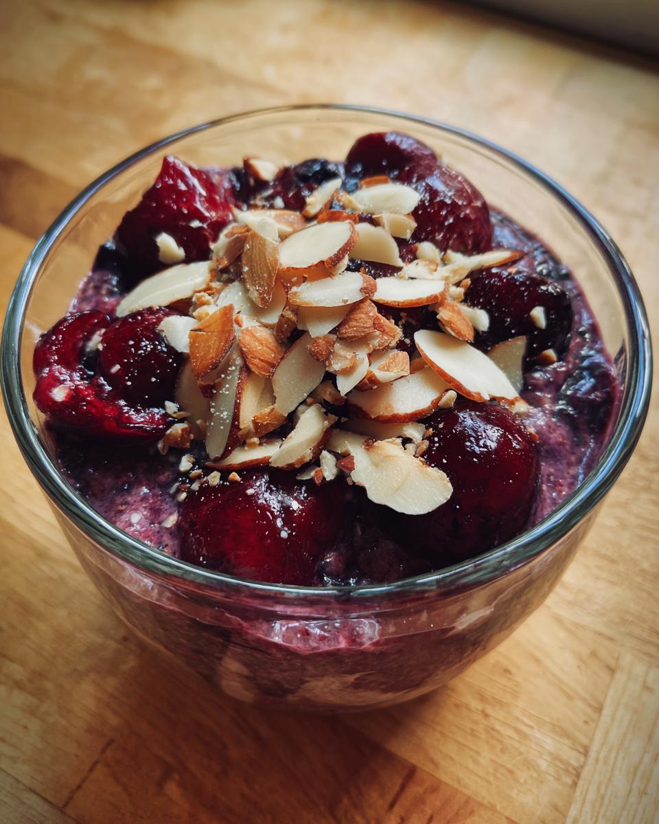 Close-up of Cherry Almond Overnight Oats topped with whole cherries and sliced almonds.