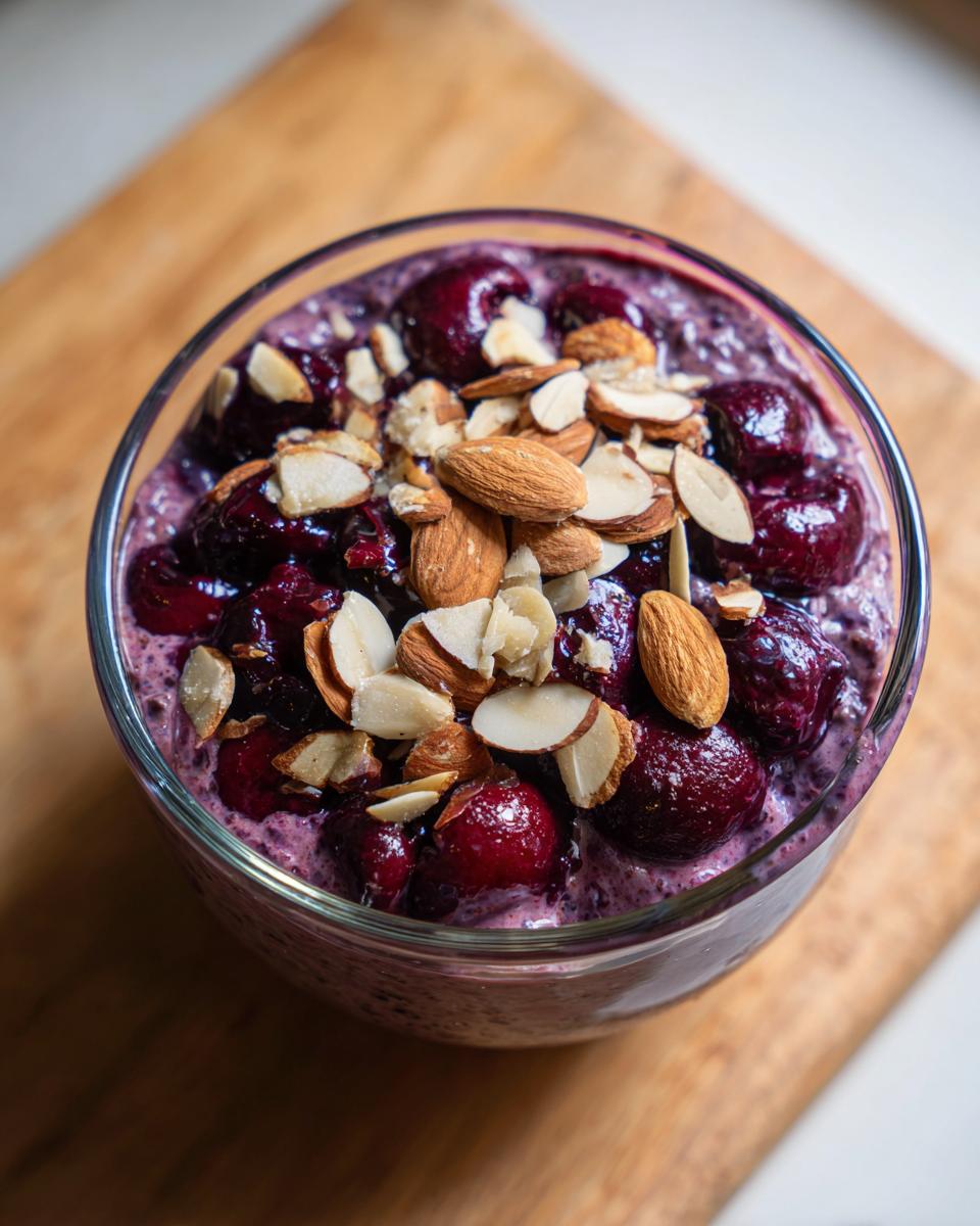 Overhead close-up of Cherry Almond Overnight Oats topped generously with whole and sliced almonds.