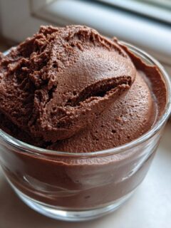 A close-up of rich, airy Cottage Cheese Chocolate Mousse served in a small clear glass.