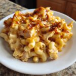 A close-up of a serving of Creamy Honey Pepper Chicken Mac And Cheese Delight with baked, browned cheese topping.