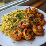 Plated serving of Grilled Garlic Butter Shrimp With Lemon Orzo, garnished with fresh parsley.