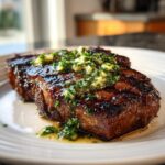 A perfectly cooked, juicy Grilled Steak With Garlic Butter melting over the top.