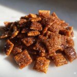 Close-up of a pile of glistening Homemade Cinnamon Toast Crunch squares covered in sparkling sugar crystals.