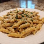 A close-up of a creamy serving of One Pot Ground Turkey Pasta topped with grated Parmesan cheese and fresh parsley.