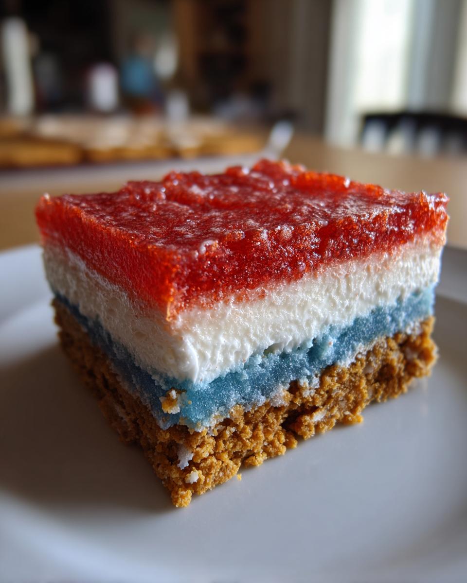 Close-up of a layered Patriotic Graham Cracker Frozen Treats slice showing graham crust, blue, white, and red layers.