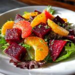Close-up of a vibrant Roasted Beet Citrus Salad featuring cubed beets, orange segments, and mixed greens.