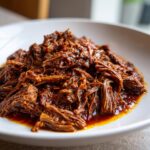 Close-up of rich, shredded beef coated in sauce, ready to serve as Slow Cooker Beef Ragu Whole30 Paleo.