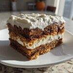 A perfect square slice of Gingersnap Icebox Cake showing layers of dark gingersnap cookies and white cream filling.