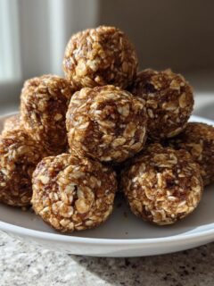 A stack of delicious No Bake Banana Cinnamon Energy Bites made with oats, piled on a small white plate.